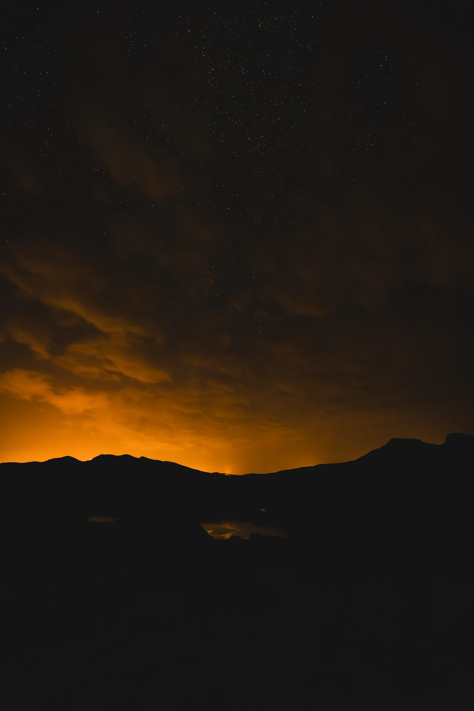 Night falling over the mountains, the horizon lit orange